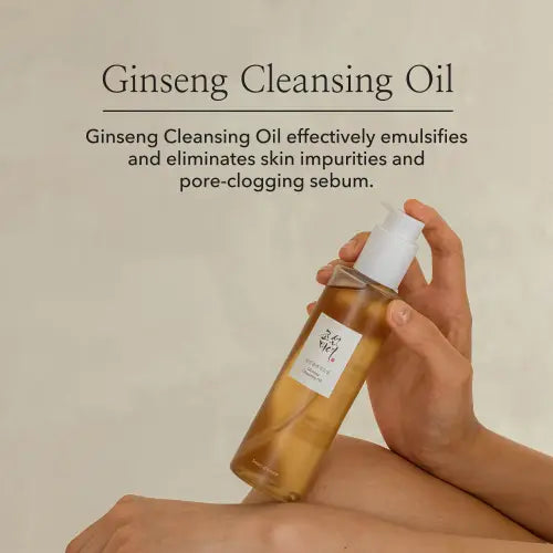 A clear glass bottle with a white pump dispenser filled with golden beauty of joseon ginseng cleansing oil 210ml