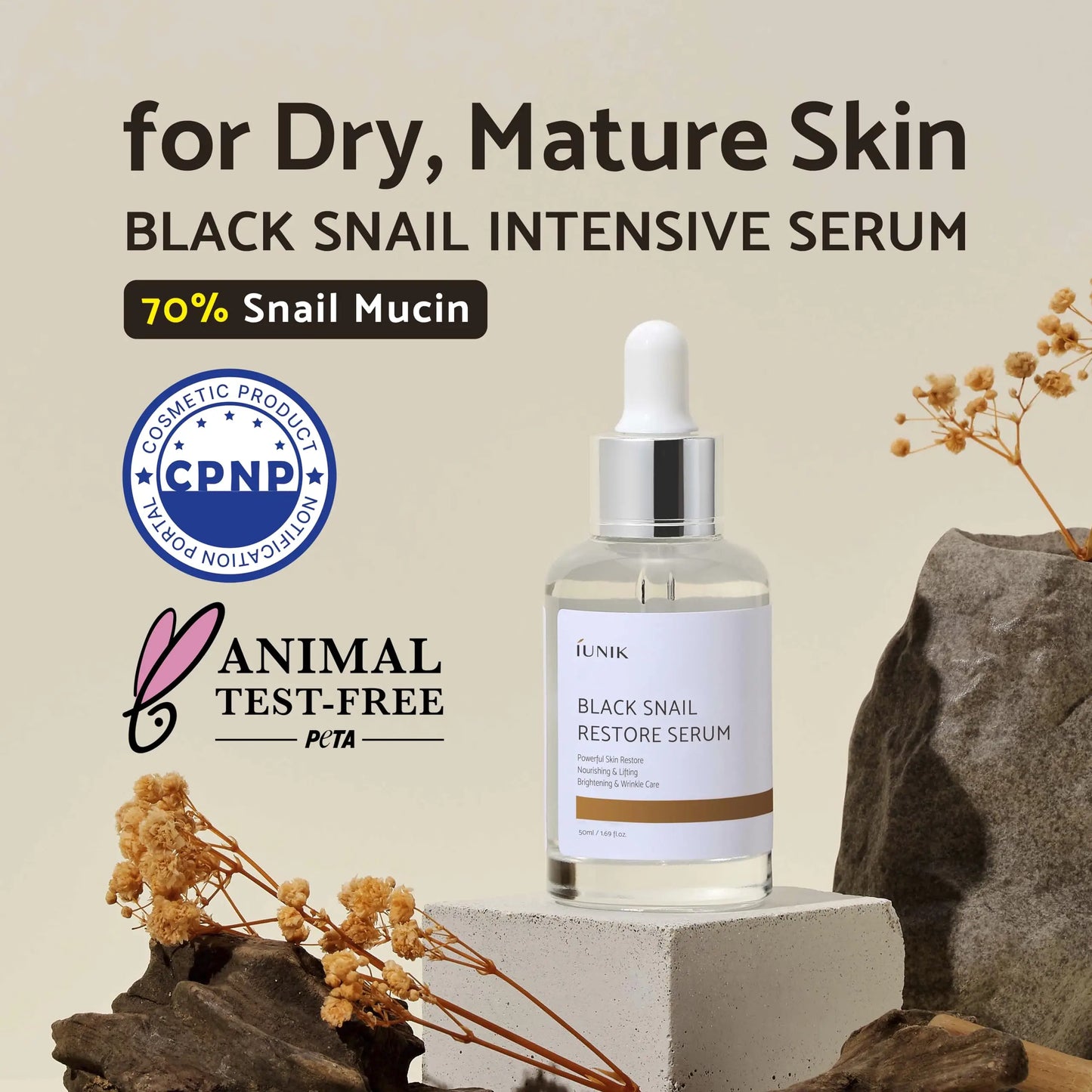 iUNIK Black Snail Restore Serum 50ml bottle on a beige background with dried flowers, highlighting 70 percent snail mucin and suitability for dry mature skin.