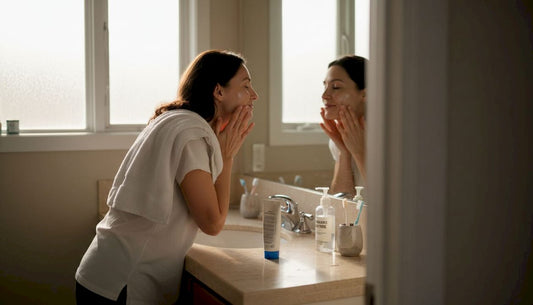 Woman applying gentle skincare in home bathroom
