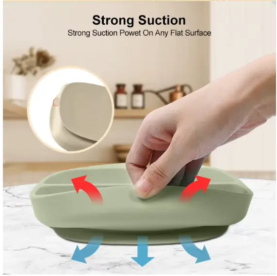 Demonstration of strong suction power on a flat surface with a green component from the 8-Piece Silicone Baby Feeding Set - Suction Plate, Bowl, Bib & Cup - BPA-Free Mess-Free First Foods Set for Babies & Toddlers.