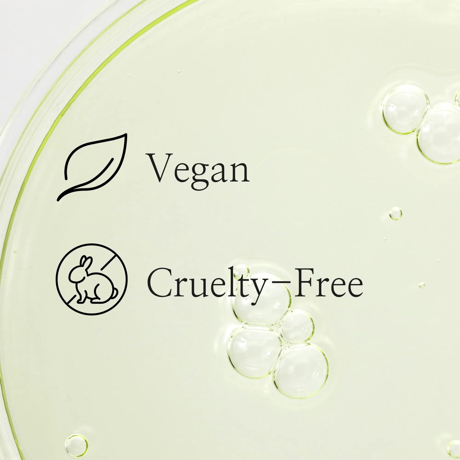 Clear liquid with bubbles in a petri dish background showing vegan and cruelty-free icons for Beauty of Joseon Calming Serum Green Tea Panthenol 30ml.