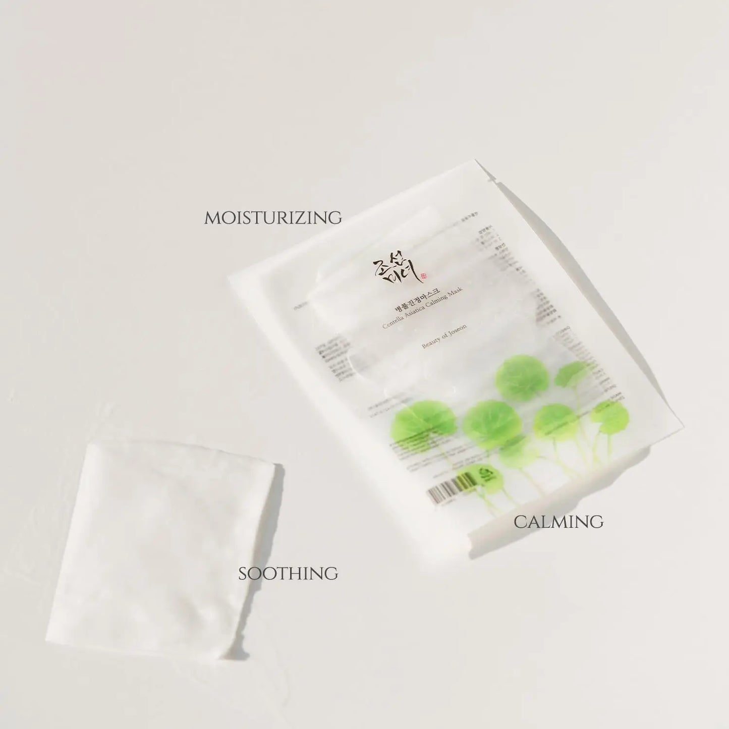 Beauty of Joseon Centella Asiatica Calming Mask packaging with green centella leaf design alongside a folded white sheet mask labeled moisturizing, soothing, and calming.
