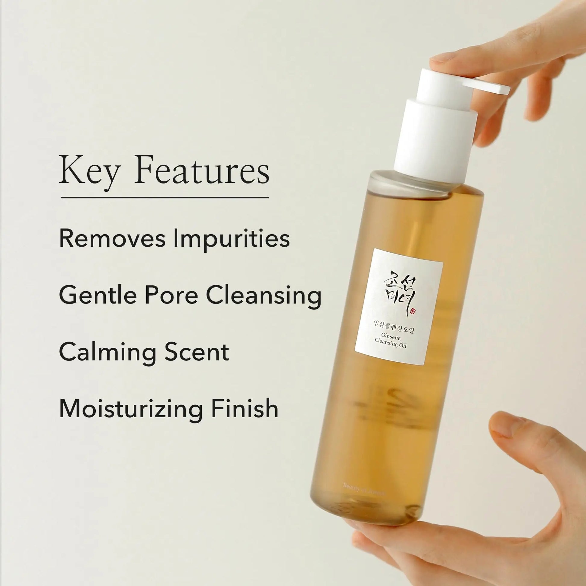 A hand holding a translucent amber bottle with a white pump dispenser labeled Beauty of Joseon Ginseng Cleansing Oil 210ml, alongside text highlighting key features: removes impurities, gentle pore cleansing, calming scent, and moisturizing finish.