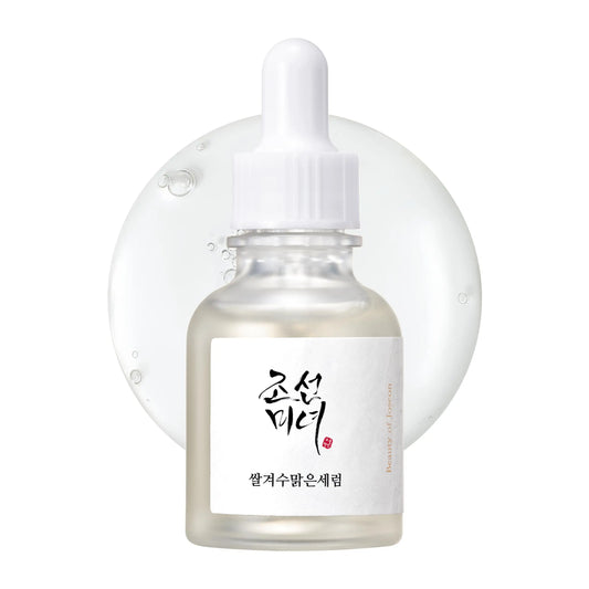Beauty of Joseon Glow Deep Serum Rice + Alpha-Arbutin 30ml in a clear dropper bottle with a white cap placed in front of a translucent serum droplet background.
