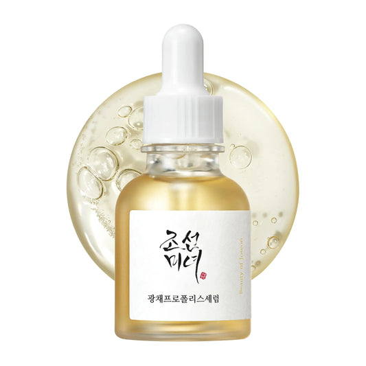 Beauty of Joseon Glow Serum Propolis and Niacinamide 30ml in a clear dropper bottle with golden liquid and a backdrop of glowing serum texture with bubbles.