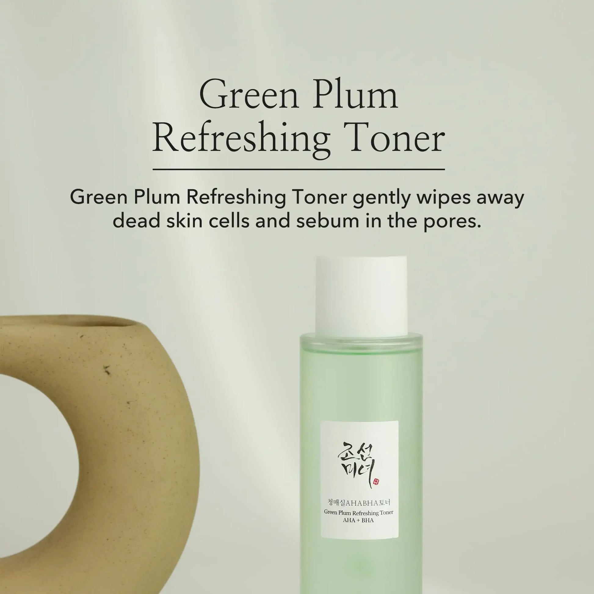 Beauty of Joseon Green Plum Refreshing Toner AHA BHA 150ml bottle next to a minimalist ceramic vase with text about its gentle exfoliating and sebum control properties.