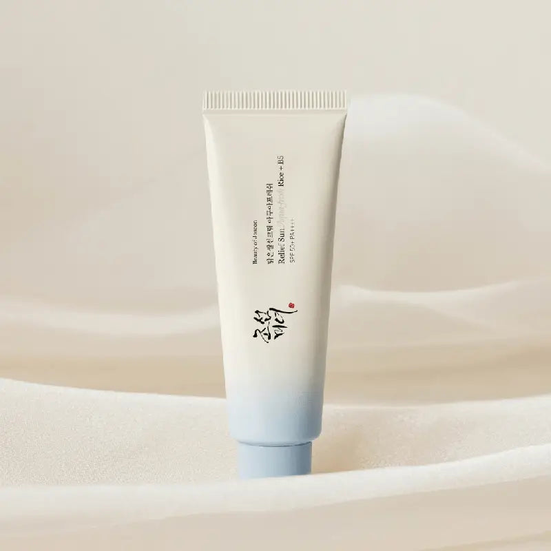 Minimalist tube of Beauty of Joseon Relief Sun Aqua-Fresh : Rice + B5 sunscreen with soft blue and white gradient background emphasizing clean skincare aesthetic.