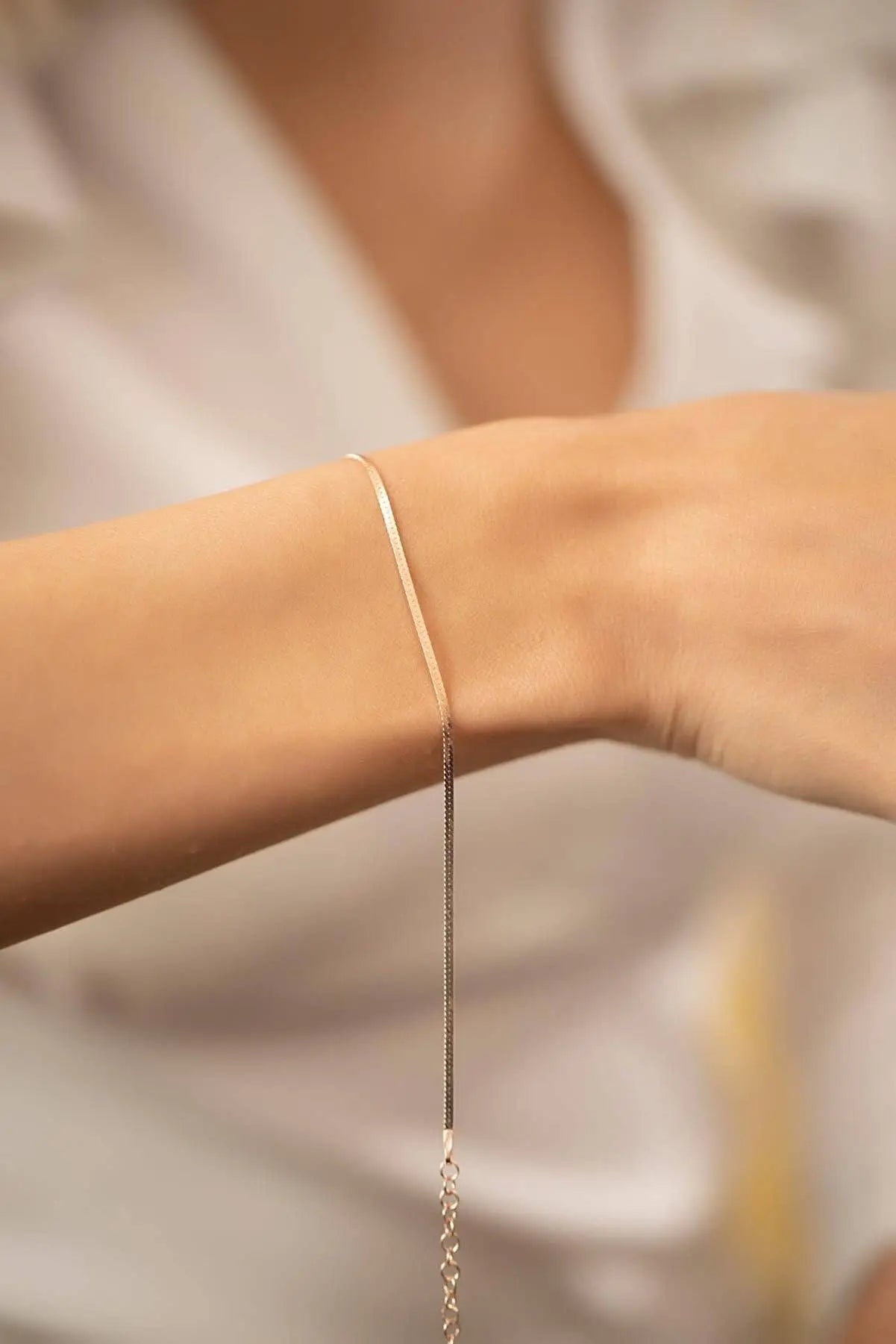 Close-up of a delicate wrist wearing Einzelstück - 14K Gold Plated Italian Rose Gold Bracelet - Rose Gold Bracelet- Gold Bracelet Gift for Women with a soft neutral background.