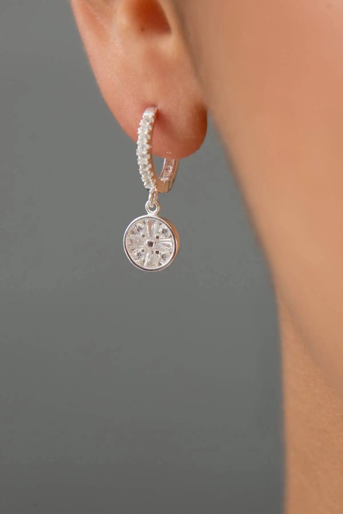 Close-up of a silver hoop earring with a delicate mandala charm hanging from it, worn on the ear, featuring in the Einzelstück - Mandala Silver Earrings - Silver Earrings- Earrings Gift for Women collection.