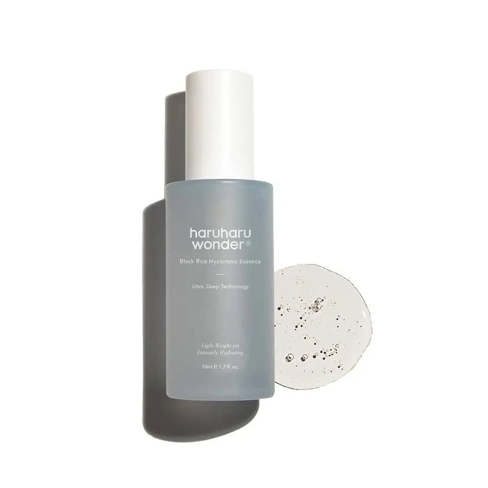 Bottle of haruharu wonder Black Rice Hyaluronic Essence 50 ml with clear serum sample beside it on a white background, highlighting hydrating skincare essence.