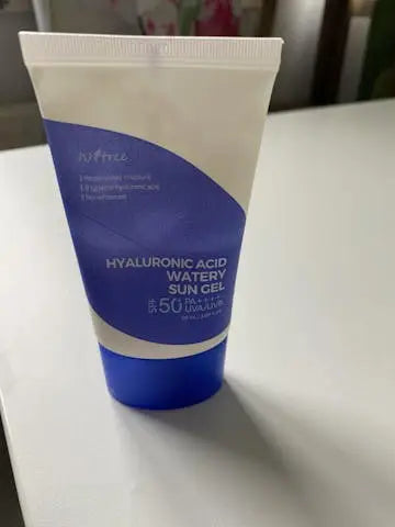 Isntree Hyaluronic Acid Watery Sun Gel 50 ml tube with blue and white design placed on a white surface, highlighting its moisturizing and sun protection features.