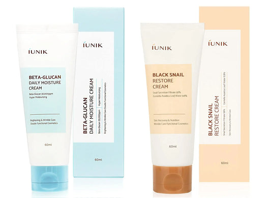 Two tubes of skincare cream with matching boxes, featuring IUNIK Beta Glucan Daily Moisture Cream 60ml in blue packaging and iUNIK Black Snail Restore Cream 60ml in beige packaging.