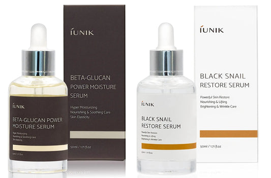 Two clear glass dropper bottles with matching boxes, featuring iUNIK Beta Glucan Power Moisture Serum 50m and iUNIK Black Snail Restore Serum 50ml for skin hydration and restoration.