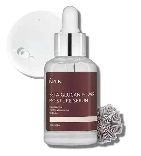 iUNIK Beta Glucan Power Moisture Serum 50ml in clear glass bottle with maroon label, placed alongside a textured botanical element and serum drops on white background