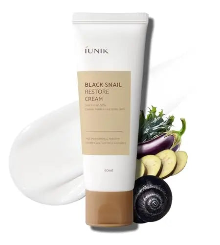Tube of iUNIK Black Snail Restore Cream 60ml with white cream texture beside fresh eggplant slices and a black snail on a white background.