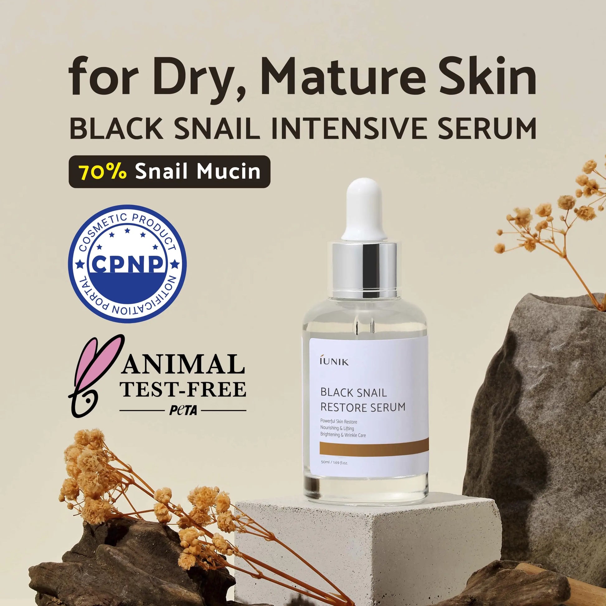 iUNIK Black Snail Restore Serum 50ml bottle on a beige background with dried flowers, highlighting 70 percent snail mucin and suitability for dry mature skin.
