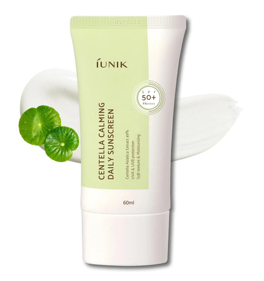 Tube of iUNIK Centella Calming Daily Sunscreen 60ml with SPF 50+ PA++++ beside green centella leaves and white sunscreen texture smear on white background.