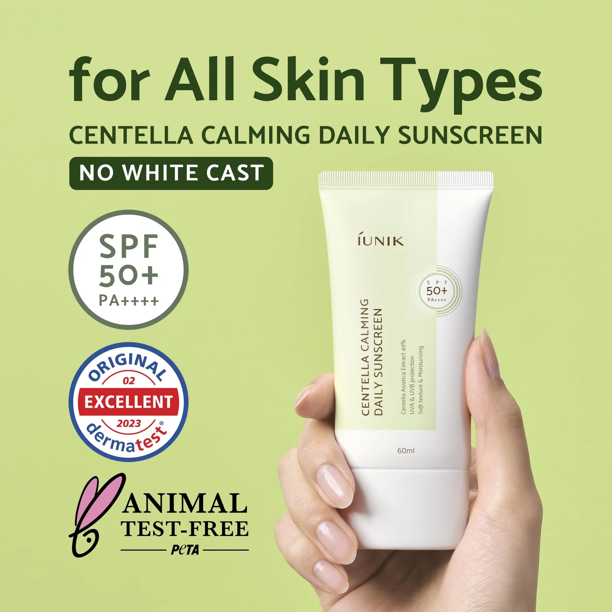 Hand holding a tube of iUNIK Centella Calming Daily Sunscreen 60ml + iUNIK Centella Bubble Cleansing Foam, 150ml with SPF 50+ PA++++, no white cast, suitable for all skin types, and labeled animal test-free and dermatologically tested.