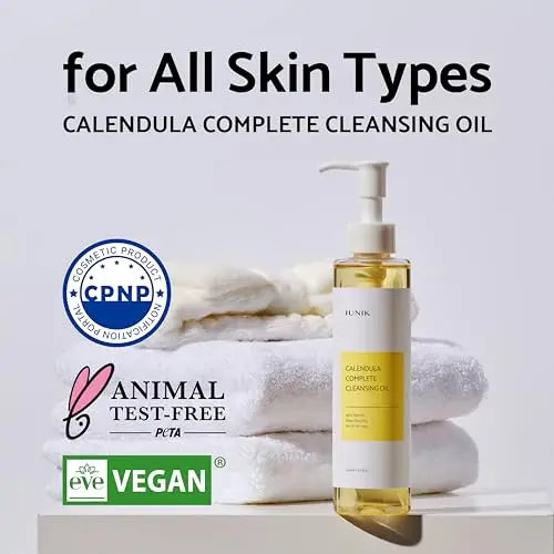 iUNIK Centella Calming Daily Sunscreen 60ml + iUNIK Calendula Complete Cleansing Oil, 200ml displayed with stacked white towels, highlighting vegan, cruelty-free, and cosmetic certification features for all skin types.