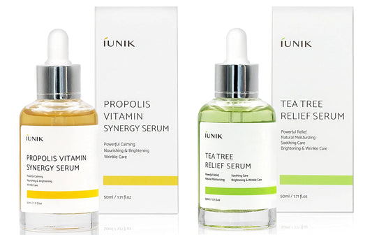 iUNIK Propolis Vitamin Synergy Serum, 50ml + iUNIK Tea tree Relief Serum 50ml displayed with dropper bottles and corresponding white boxes for skincare focused on calming, nourishing, brightening, and wrinkle care.