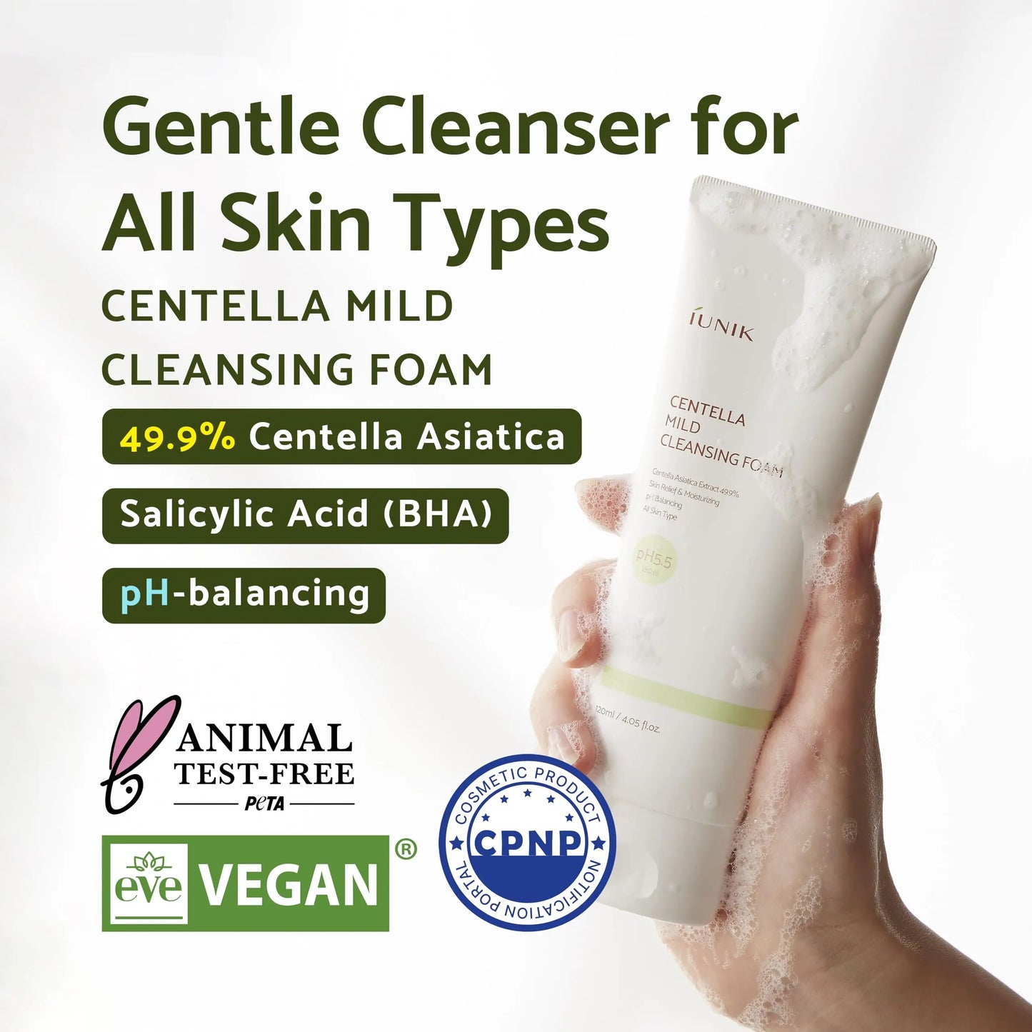 Hand holding a foamy tube of iUNIK Tea tree Relief Serum 50ml + iUNIK Centella Mild Cleansing Foam, 120ml with text highlighting gentle cleanser for all skin types, 49.9% Centella Asiatica, salicylic acid, pH-balancing, animal test-free and vegan certifications.
