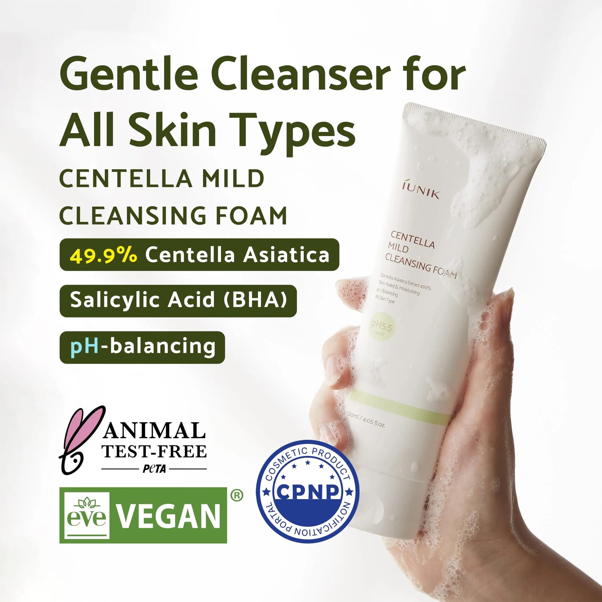 Hand holding a foamy tube of iUNIK Tea tree Relief Serum 50ml + iUNIK Centella Mild Cleansing Foam, 120ml with text highlighting gentle cleanser for all skin types, 49.9% Centella Asiatica, salicylic acid, pH-balancing, animal test-free and vegan certifications.