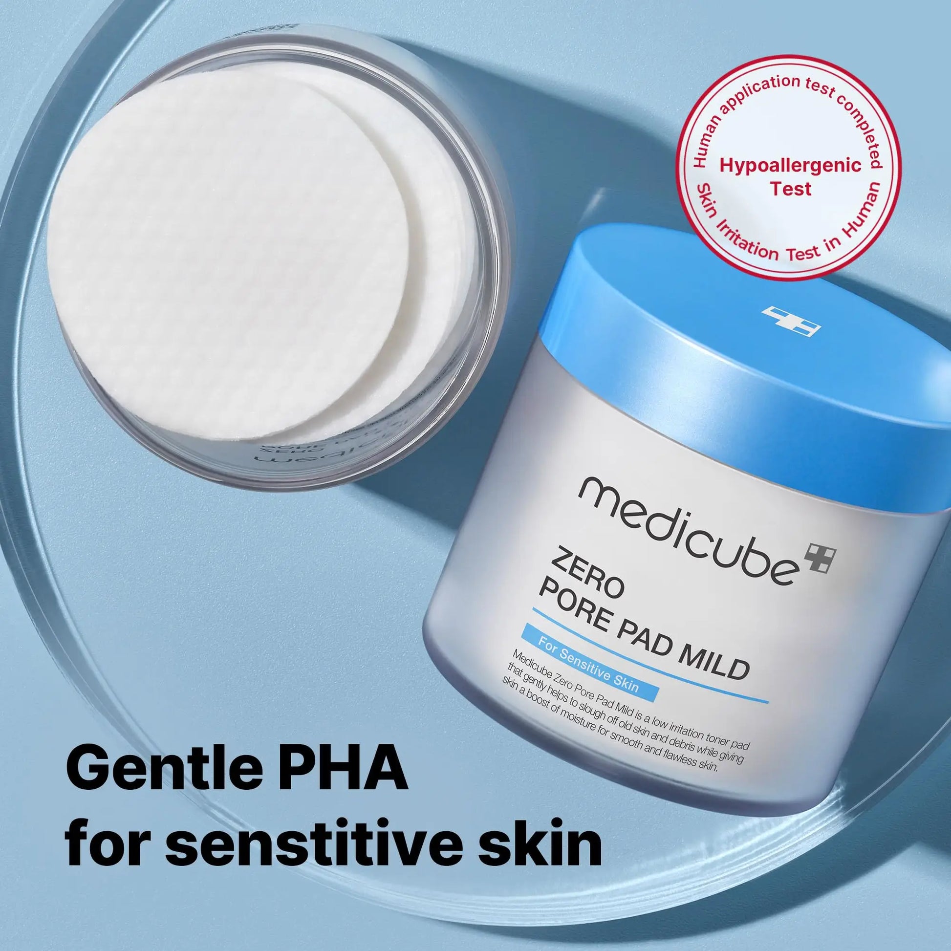 medicube Zero Pore Pad Mild 155g container with cotton pads beside it, emphasizing gentle PHA formula for sensitive skin and a hypoallergenic test approval badge on a blue background
