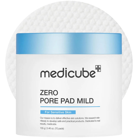Container of medicube Zero Pore Pad Mild 155g with blue lid placed on a textured white cotton pad background, designed for sensitive skin and gentle exfoliation.