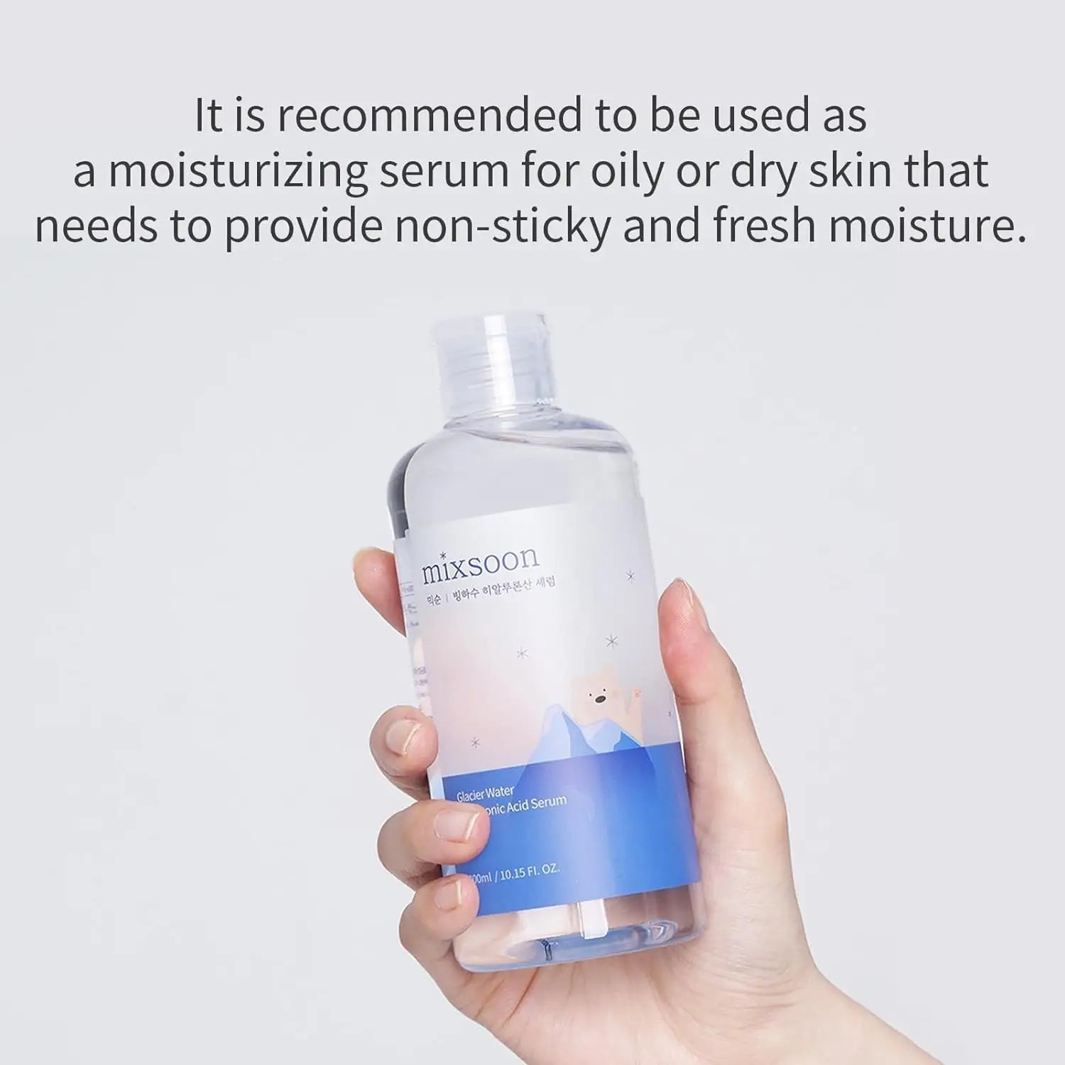 Hand holding a clear bottle of Mixsoon Glacier Water Hyaluronic Acid Serum 300ml with a blue label, recommended for moisturizing oily or dry skin with non-sticky fresh moisture.