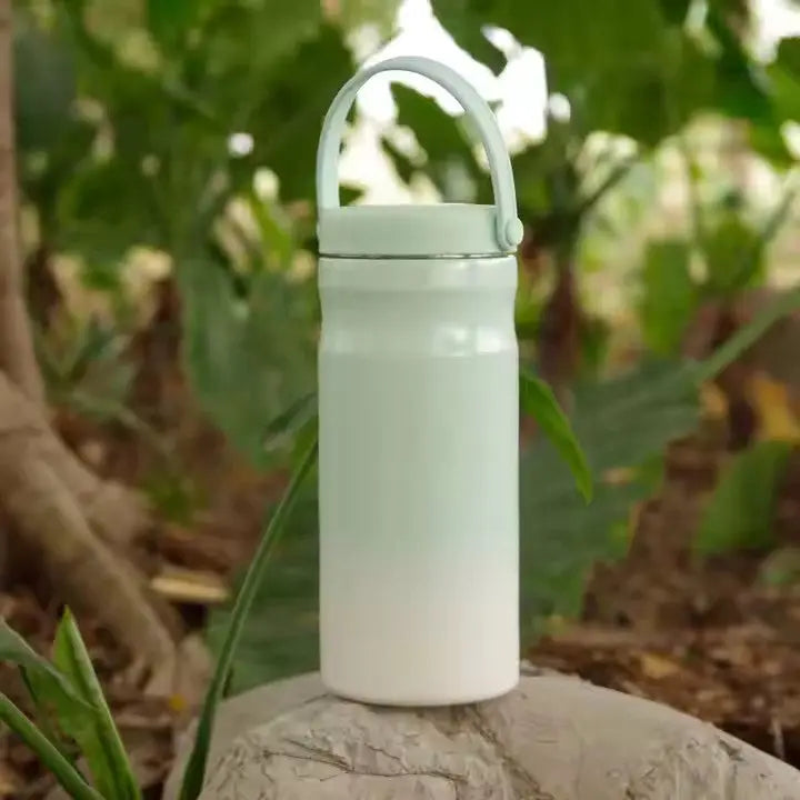 Portable Breast Milk and Water Cooler 24-Hour Extended Cooling | Ice-Free Portable Milk Storage for Travel and Work | All-in-One Ice-Free Cooler and Baby Bottle in soft green and white, with a handle for easy carrying outdoors.