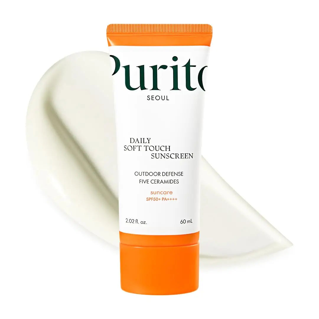 Tube of PURITO Daily Soft Touch Sunscreen with orange cap and a creamy white sunscreen texture in the background for facial protection and hydration.
