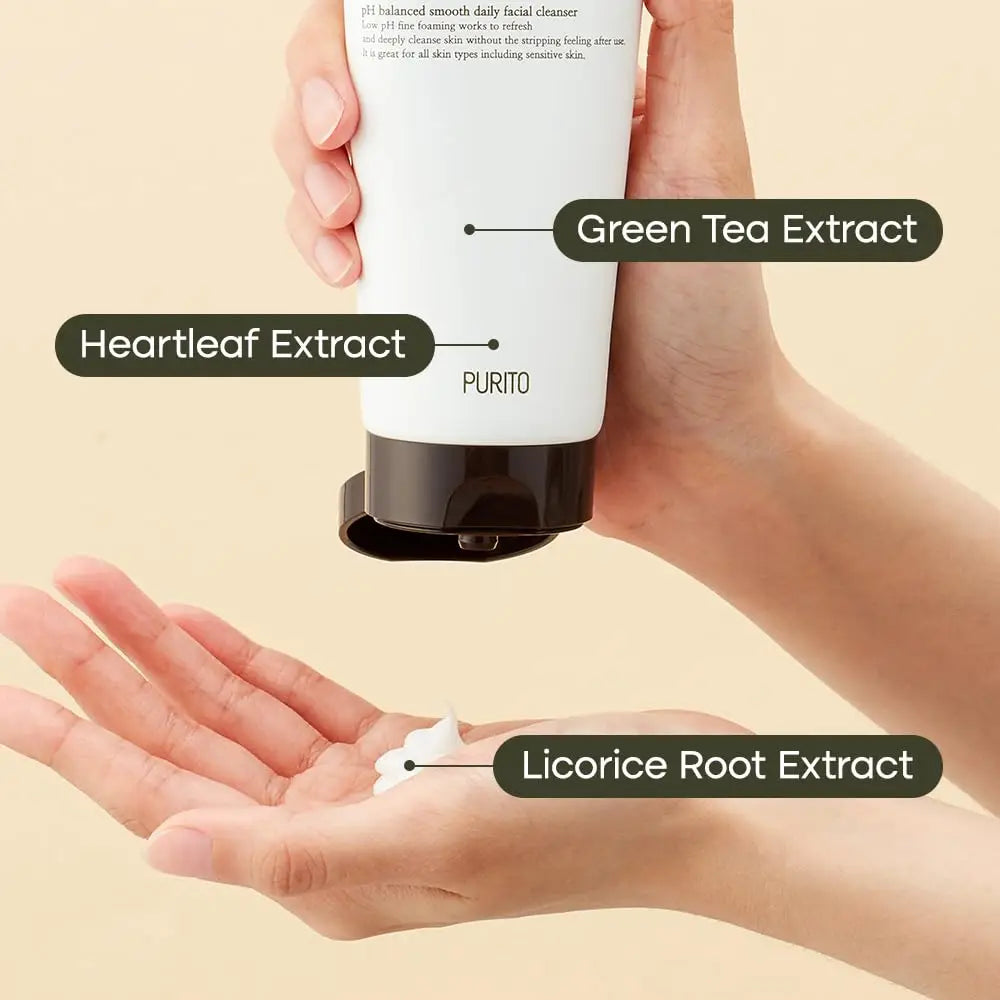 Hand holding a tube of PURITO From Green Deep Foaming Cleanser 150ml dispensing foam, highlighting key ingredients Green Tea Extract, Heartleaf Extract, and Licorice Root Extract.