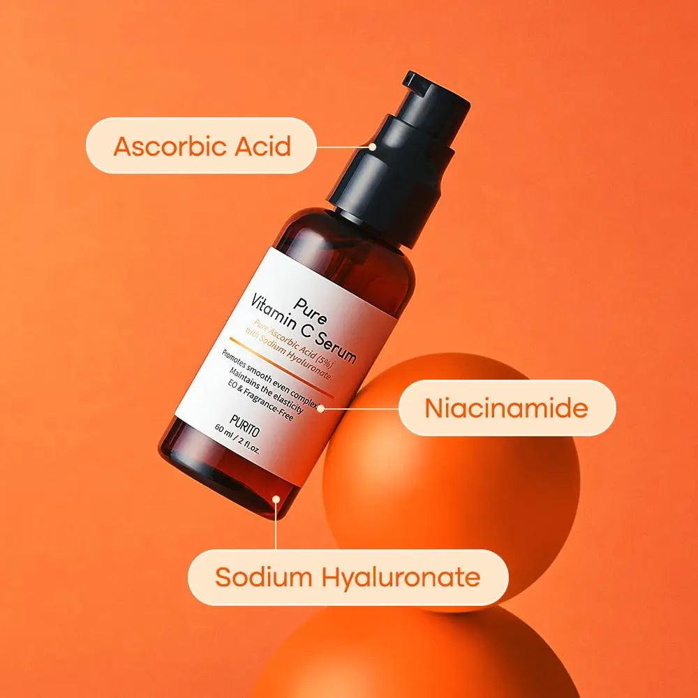 Bottle of PURITO Pure Vitamin C Serum 60ml with labeled ingredients Ascorbic Acid, Niacinamide, and Sodium Hyaluronate over an orange background with round props.