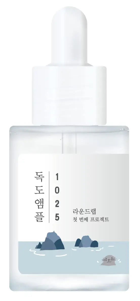Transparent dropper bottle of ROUND LAB 1025 Dokdo Ampoule Serum 45g with minimalist design featuring small rocks and a swimming seal illustration on the label.
