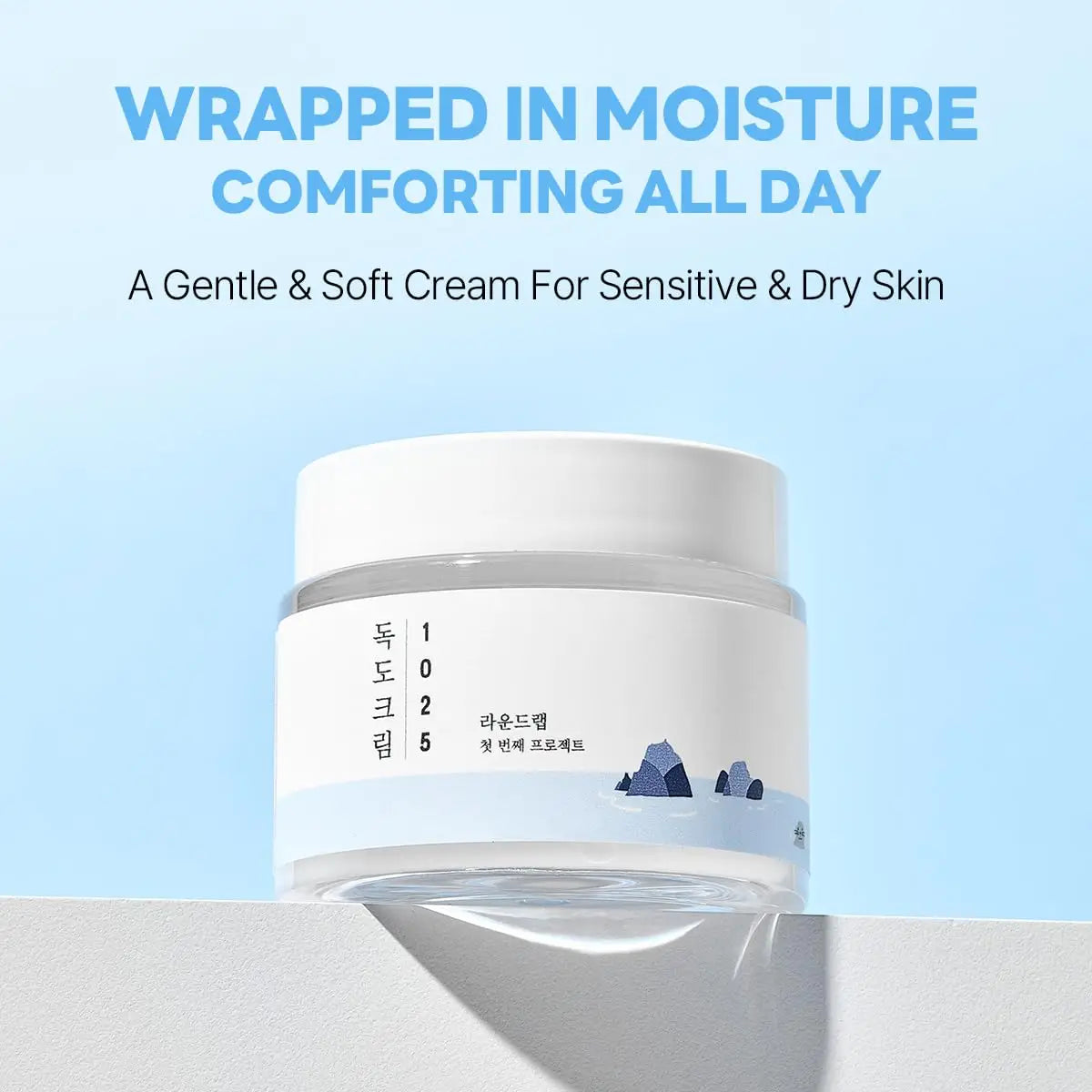 ROUND LAB 1025 DOKDO CREAM 80ml in a white jar with blue minimalist mountain design, promoting gentle, soft moisture for sensitive and dry skin.