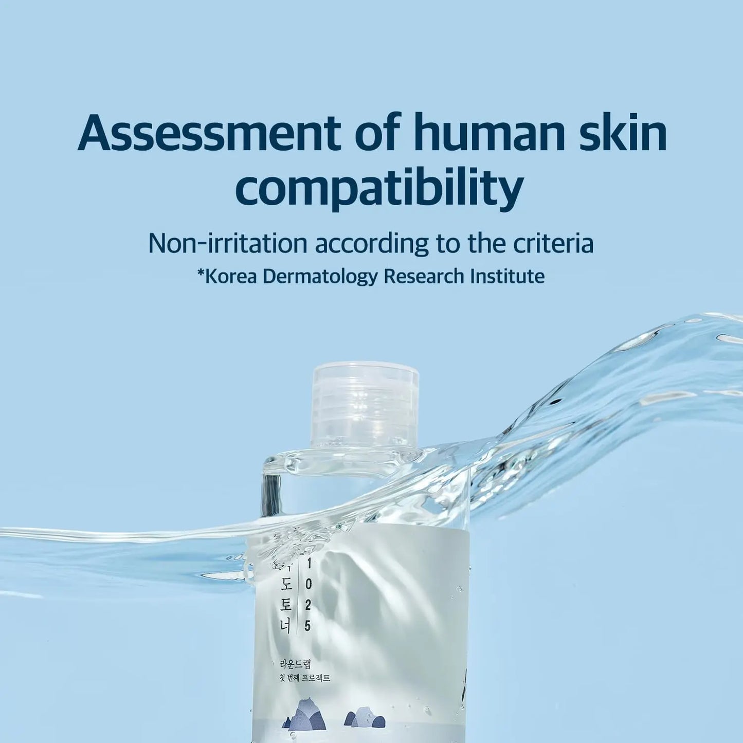 Clear bottle of ROUND LAB 1025 Dokdo Toner 100ml submerged in water with text stating assessment of human skin compatibility and non-irritation confirmed by Korea Dermatology Research Institute.