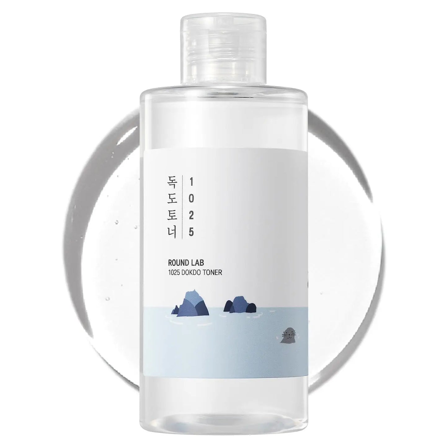 Clear plastic bottle of ROUND LAB 1025 Dokdo Toner 100ml with minimalist white label featuring ocean rocks and gentle waves illustration on a white background with translucent toner drop behind it.