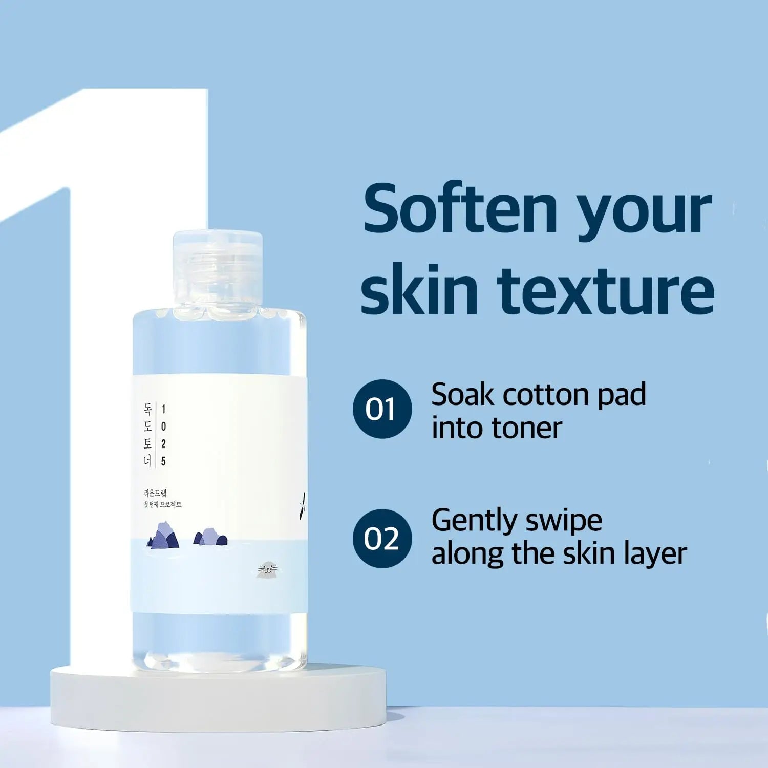 Bottle of ROUND LAB 1025 Dokdo Toner 100ml displayed on a round pedestal with instructions to soak a cotton pad and gently swipe along the skin to soften skin texture.