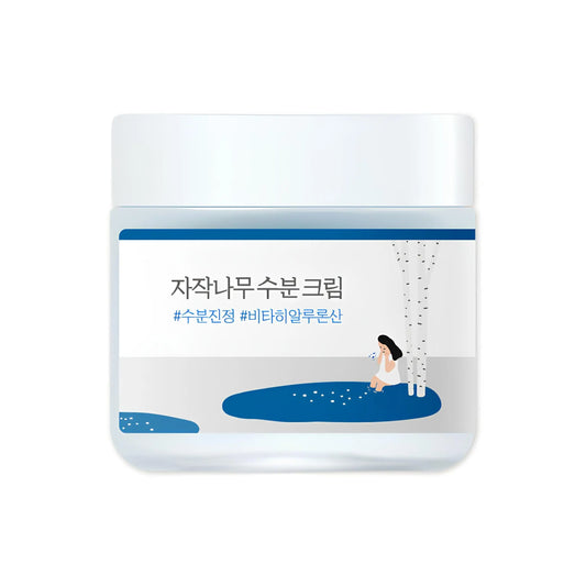 Container of ROUND LAB Birch Juice Moisturizing Cream 80ml featuring minimalist design with illustration of a woman sitting by birch trees beside a blue water body.