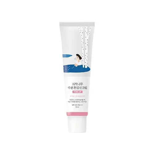 ROUND LAB Birch Juice Moisturizing Tone Up Sunscreen 50ml in a white tube featuring a minimalistic design with birch trees and a woman sitting by a blue pond, SPF 50 protection.