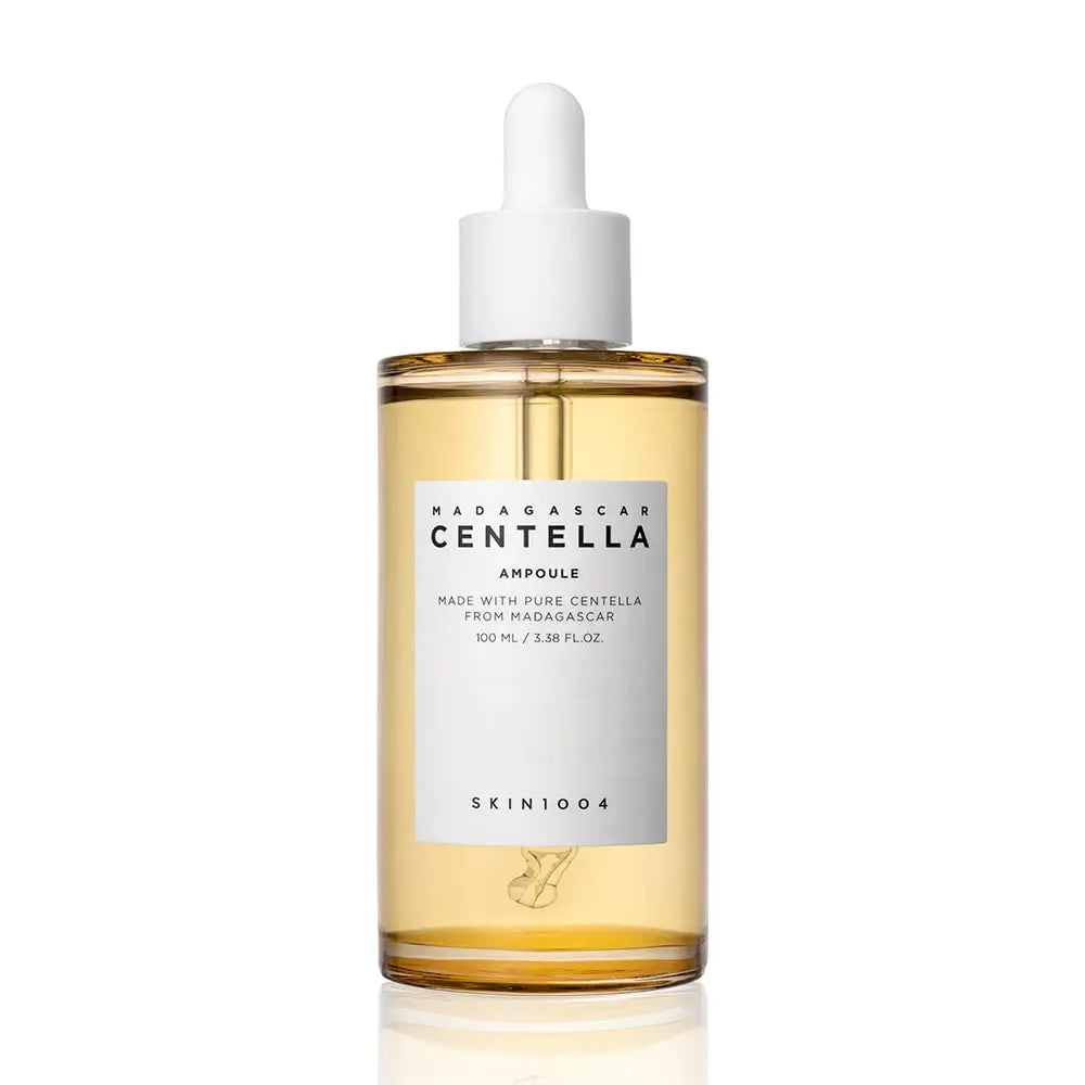 Skin 1004 Madagascar Centella Asiatica Ampoule Facial Serum 100ml in a clear bottle with white dropper cap, featuring light amber serum inside for soothing skincare.
