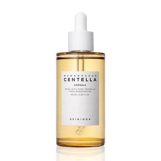 Skin 1004 Madagascar Centella Asiatica Ampoule Facial Serum 100ml in a clear bottle with white dropper cap, featuring light amber serum inside for soothing skincare.