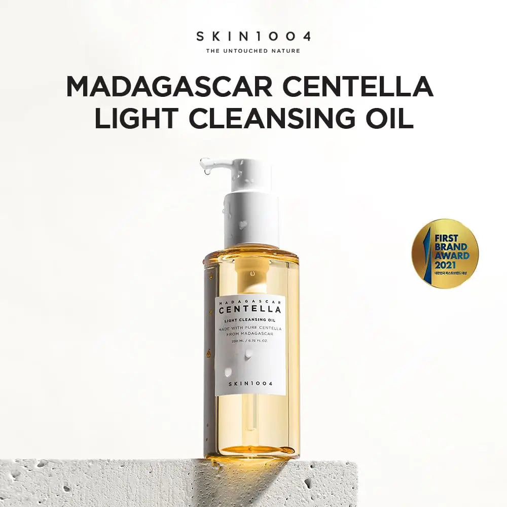 Skin 1004 Madagascar Centella Light Cleansing Oil 200ml bottle with pump on a textured white block, showcasing the light golden oil and a first brand award 2021 badge.