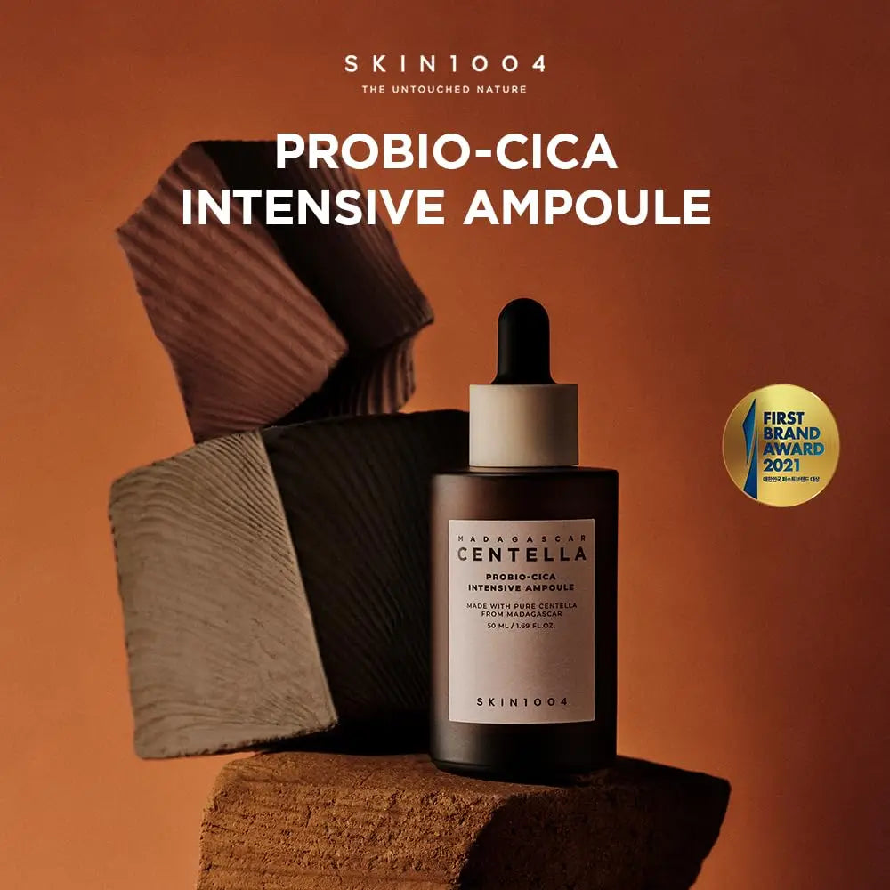 Skin 1004 Madagascar Centella Probio-Cica Intensive Ampoule 95ml bottle with dropper displayed on textured brown blocks with a warm brown background and a first brand award 2021 badge.